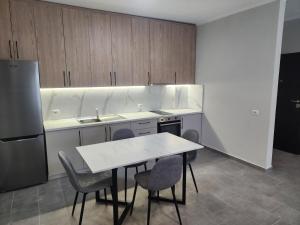 a kitchen with a table and chairs and a refrigerator at Meteor Apartments Golem in Golem