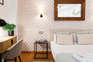 a bedroom with two beds and a mirror and a table at C15 - Charming Modern Studio in the Centre in Málaga