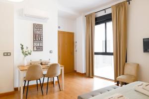 a room with a table and chairs and a bed at C15 - Charming Modern Studio in the Centre in Málaga