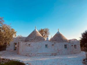 a stone building with two towers on top of it at I Trullarelli in Cozzana