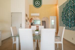 ein Esszimmer mit einem Glastisch und weißen Stühlen in der Unterkunft 2BR House - Private Patio - Acapulco in Acapulco