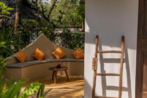 a chair next to a couch with pillows on it at Mr Kahawa in Paje