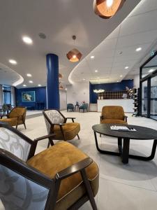 a lobby with chairs and a table in a room at DOMITYS Nancy in Nancy +14 photos