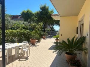 a patio with a table and chairs and plants at Pensione Vagnozzi in Grottammare