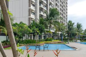 a resort with a swimming pool and palm trees at Calma 2BR II at Skyhouse Apartment in Samporo
