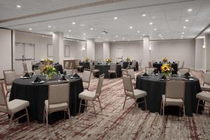 a conference room with tables and chairs with flowers on them at Hilton Garden Inn Philadelphia-Fort Washington in Fort Washington +26 photos