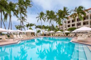 a pool at the resort with chairs and umbrellas at Casa Marina Key West, Curio Collection by Hilton in Key West