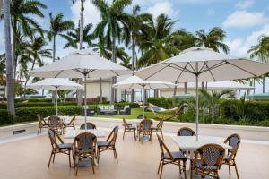 an outdoor patio with tables and chairs and umbrellas at Casa Marina Key West, Curio Collection by Hilton in Key West