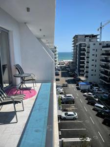 ein Balkon mit Blick auf einen Parkplatz mit Autos in der Unterkunft Apartament Wave5 in Năvodari