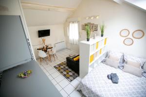 a small living room with a bed and a table at L'Evasion - coeur de ville - WIFI - Gare in Les Mureaux