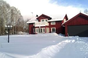 a red house with snow in front of it at Private apartment in Innertavle in Umeå