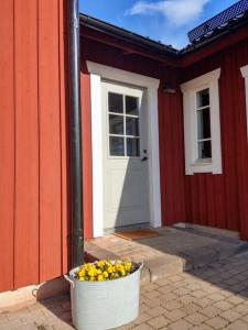 a white pot of flowers in front of a red building at Private apartment in Innertavle in Umeå +3 photos