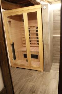 un armario de madera con una puerta de cristal en una habitación en Leamorine House, en Predappio