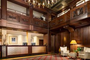a lobby of a hotel with a reception desk and chairs at Vienna House by Wyndham Thüringer Hof Eisenach in Eisenach