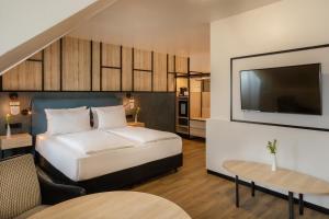 a bedroom with a bed and a flat screen tv at Hotel München City Center affiliated by Meliá in Munich +63 photos
