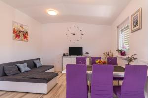 a living room with a table and purple chairs at Holiday Home Zala with Jacuzzi - Happy Rentals in Moravske Toplice