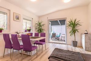 a living room with a dining room table and purple chairs at Holiday Home Zala with Jacuzzi - Happy Rentals in Moravske Toplice