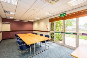 a conference room with a wooden table and chairs at Milestone Peterborough Hotel A1M, Sure Hotel Collection by Best Western in Peterborough