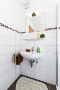 ein weißes Badezimmer mit Waschbecken und Spiegel in der Unterkunft Ferienwohnungen und Ferienhaus Polmann in Nordwerdum in Werdum + 60 Fotos