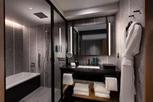 a bathroom with a sink and a tub and a mirror at Hilton Kyoto in Kyoto