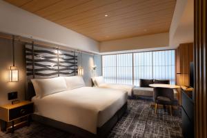 a hotel room with two beds and a desk at Hilton Kyoto in Kyoto