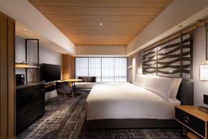 a hotel room with a large bed and a desk at Hilton Kyoto in Kyoto