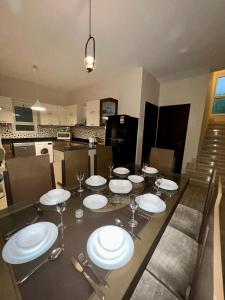 a dining room table with plates and wine glasses at KUBA LuXuS - VillA in Sahl hashesh-hurghada in Hurghada