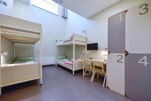 阿尼克什奇艾Nykščio Hostel的有两张双层床和一张书桌的房间