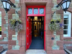 a red door leading into a building with flowers at Dunningwell Hall in Duddon