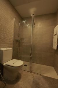 a bathroom with a toilet and a glass shower at Hotel The Park Derio in Derio +26 photos