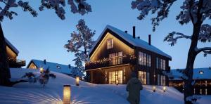 萨伦Lindvallen Ski In Söderåstorget的站在雪中房子前面的人