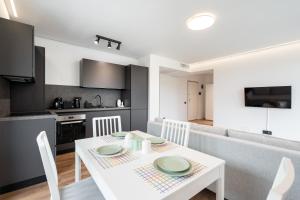 cocina y comedor con mesa blanca y sillas en La Vie á Iancu, en Voluntari 206 fotos más