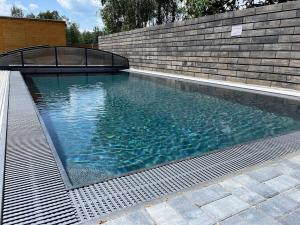 a large swimming pool next to a brick wall at Hnízdo Na Hůrce in Horní Planá