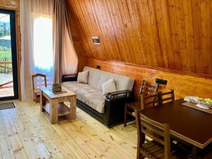 a living room with a couch and a table at Lela's Cottage in Mestia