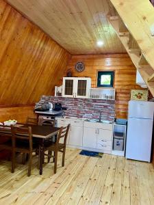 a kitchen with a table and a refrigerator at Lela's Cottage in Mestia +34 photos