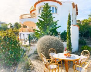 ein Tisch und Stühle vor einem Haus in der Unterkunft Traumvilla Mimosa, Costa Blanca in Cumbre del Sol