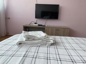 a pile of white towels sitting on a bed at Niki Apartman in Kruševac