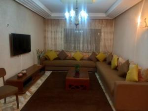Una sala de estar con un sofá y un televisor. en Beach Marina Center, en Tánger