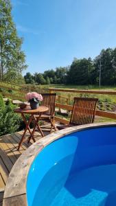 two chairs and a table next to a swimming pool at Villa Kaunisvirta in Pyhtaa