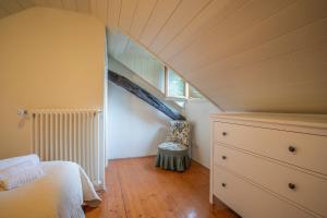ein Dachzimmer mit einem Bett und einer Kommode in der Unterkunft Casa Giuliana casa con giardino privato in Orta San Giulio + 54 Fotos