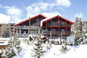 a large red building in the snow with trees at Hotel Biancaneve in Sestriere +29 photos