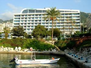a boat in the water in front of a large building at Chalet Full Sea View in Jounieh in Ed Dkârîne