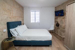 a bedroom with a blue bed and a window at Raianos in Tui