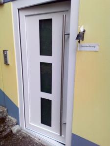 a white door with a sign on a wall at FeWo Schwäbische Alb in Burladingen