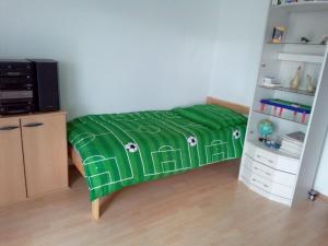 a bedroom with a bed with a green blanket at FeWo Schwäbische Alb in Burladingen