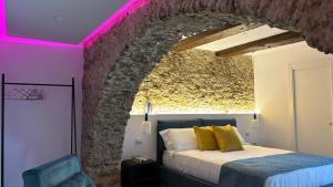 a bedroom with a bed and a stone wall at Arco di Pietra B&B in Crotone