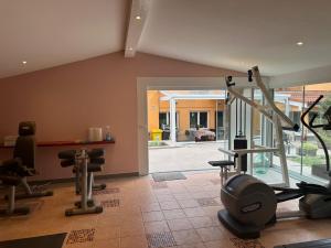 Un gimnasio con cintas de correr y equipos de ejercicio en una habitación. en Casa Portocalie, en Cisnădioara