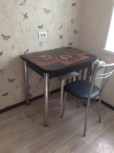 stół i 2 krzesła w pokoju w obiekcie Apartment Ural on Evteeva 5 w mieście Czelabińsk