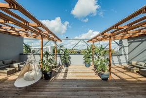 a balcony with potted plants and a hammock at Zaliakalnio Terasos apartamentai 2 in Kaunas