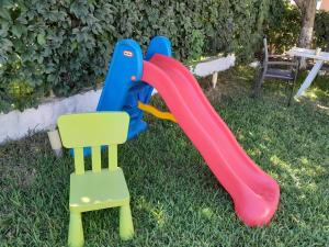 two childrens play equipment on the grass next to a chair at Vasiliki in Kavála